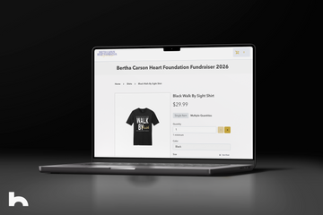 Laptop displaying a t-shirt design for a fundraiser on a dark background