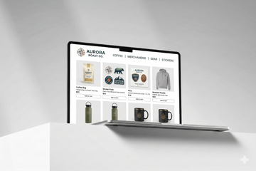Laptop displaying the Aurora Coffee Co. website on a white surface with a light gray background